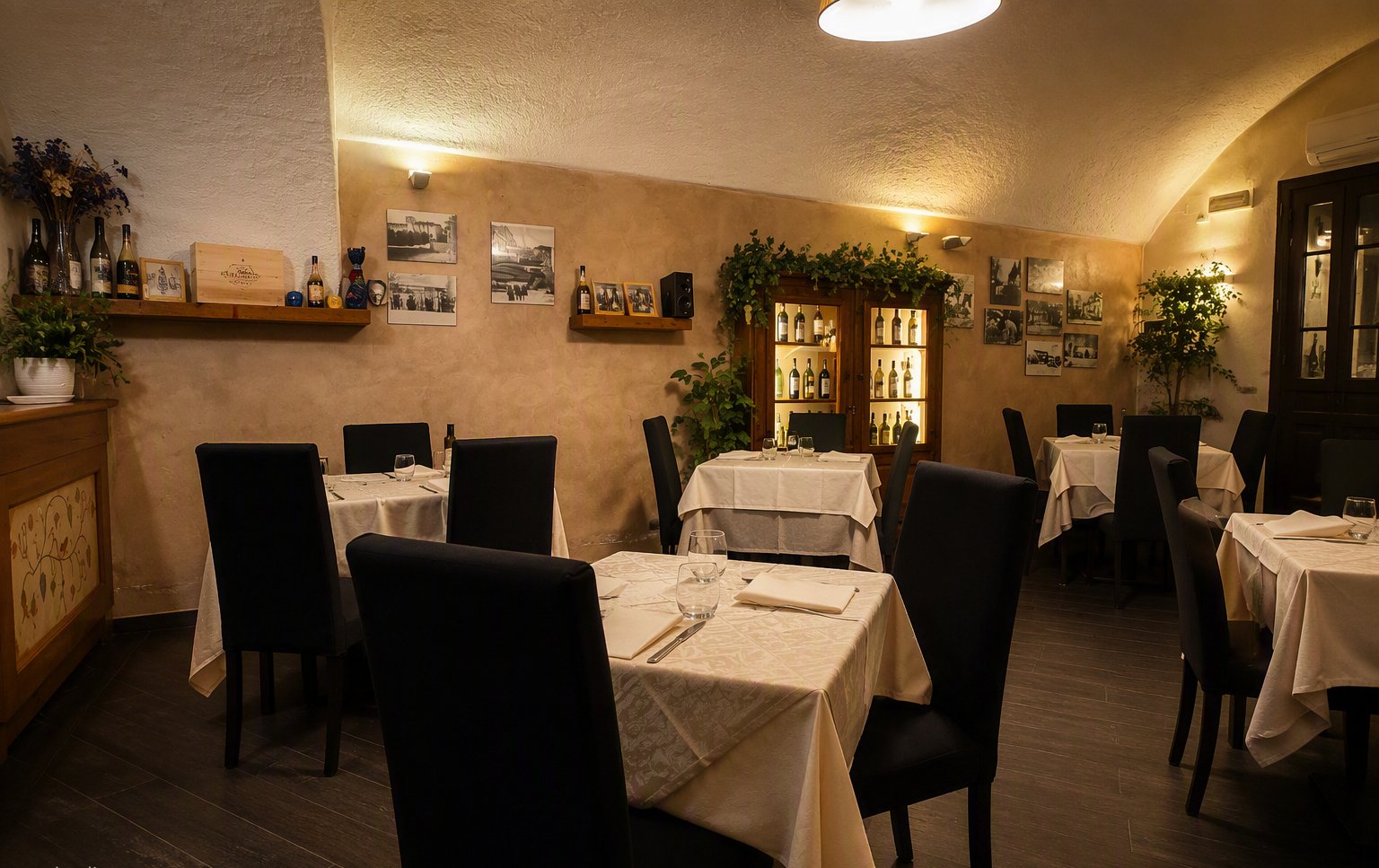 La sala del ristorante con i tavoli apparecchiati e le foto alle pareti